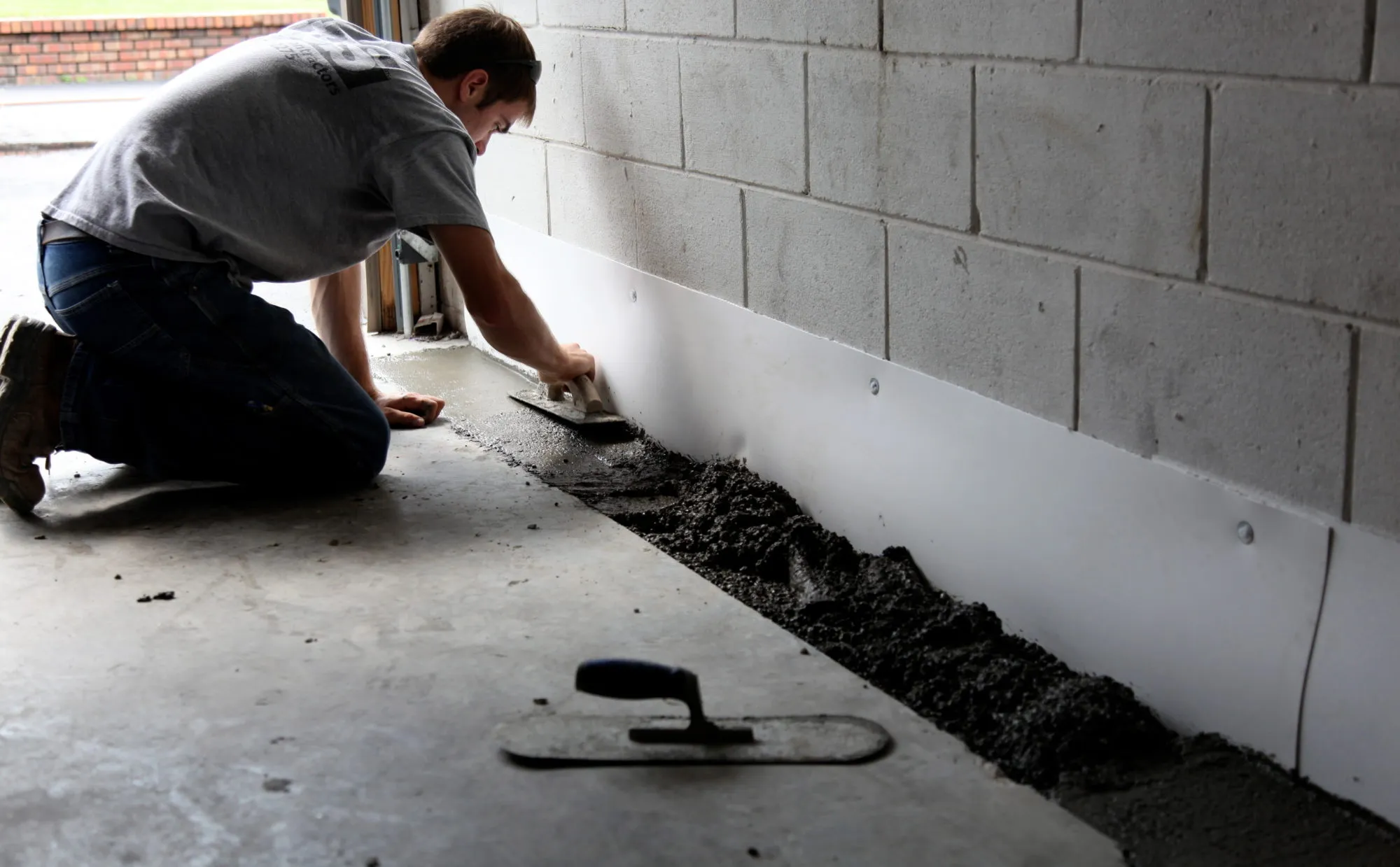 Foundation repair specialist measuring settlement and reviewing structural movement with professional tools