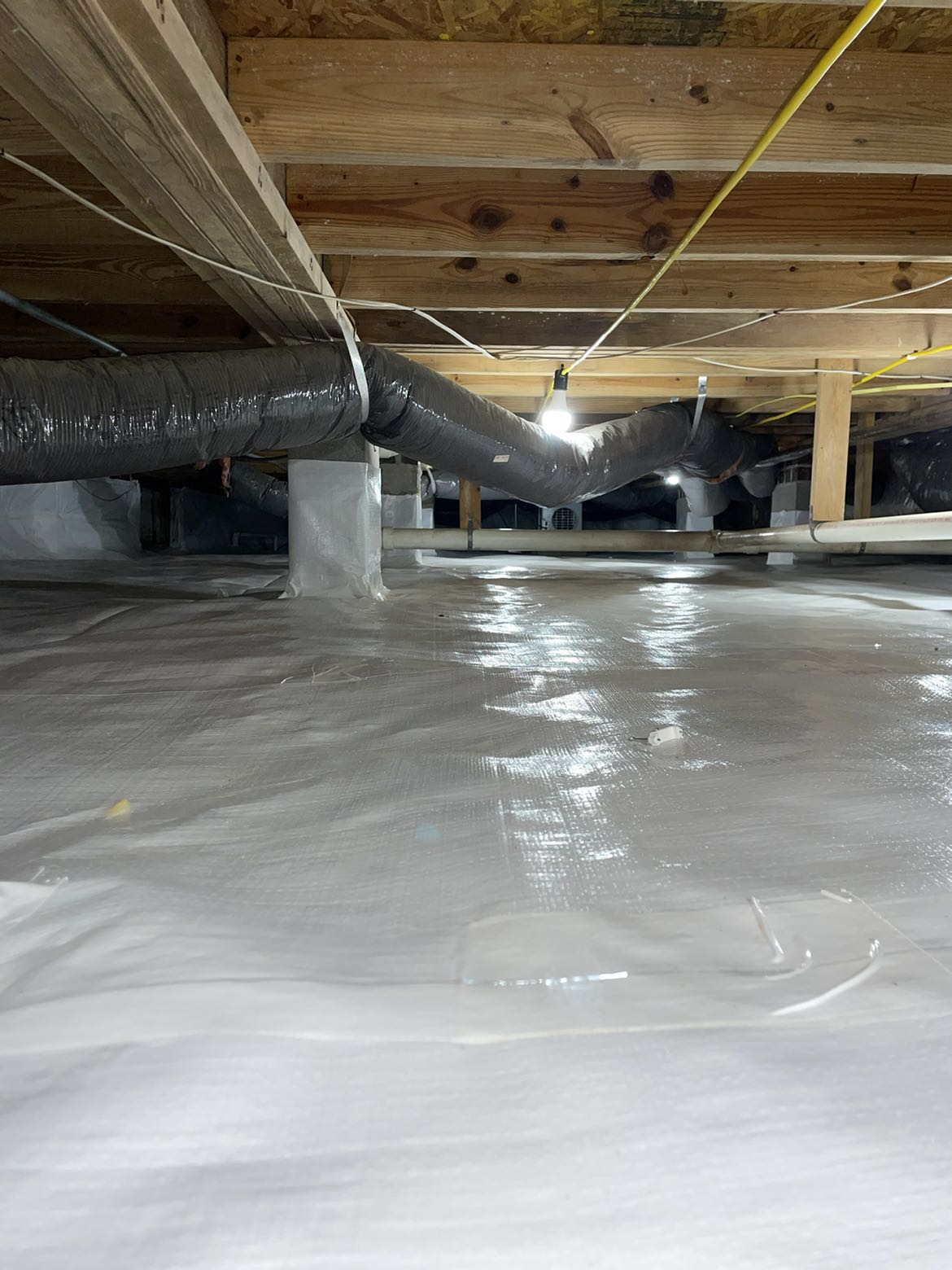 Technician checking wall cracks and floor slope in Central North Carolina home with settlement issues